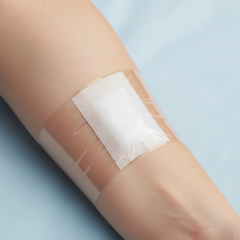 Tape securing wound dressing