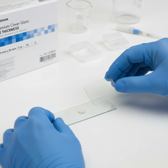 Hands placing cover glass on slide